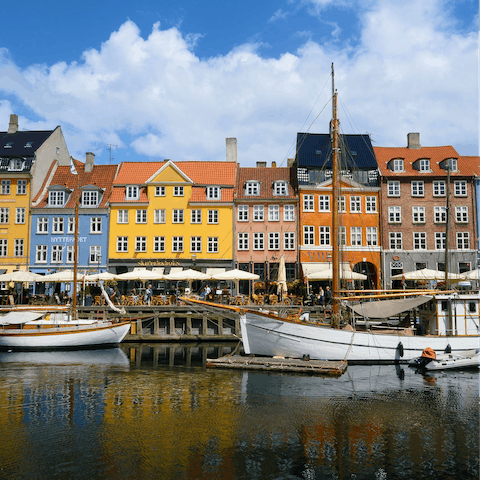 Discover Nyhavn's  waterfront eateries and lively bars lining the canals