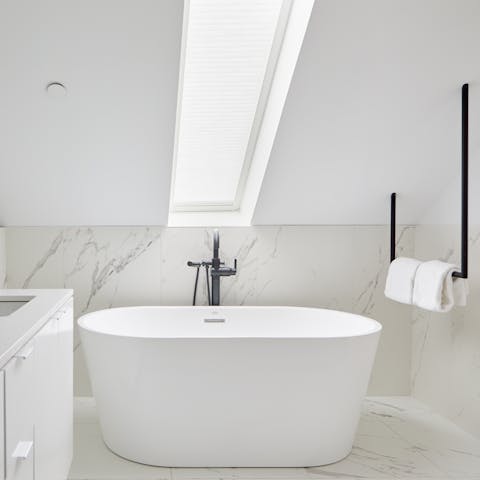 Enjoy a long soak in the freestanding tub in the marble bathroom