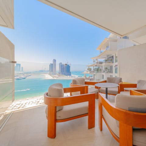 Gather on the sea-facing balcony to toast a happy holiday in Dubai at sunset