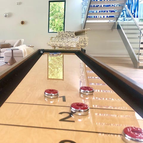 Challenge someone to a game of shuffleboard 