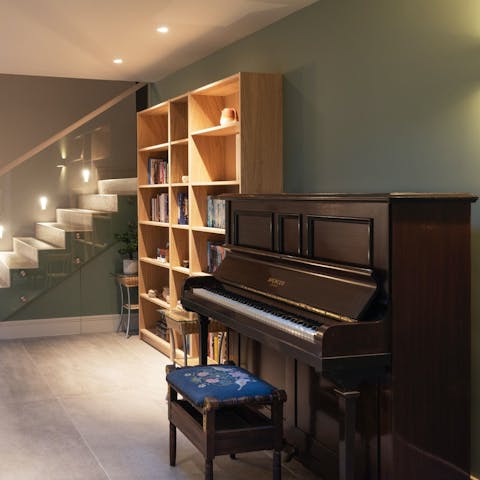 Wander down to the lower level, where a piano, bookshelf, and table tennis await