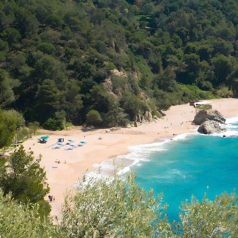 Sprawl out on the sands of Platja de Canyelles, a ten-minute drive away