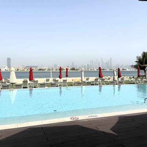 Admire the Dubai skyline from the shared pool