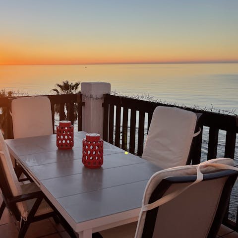 Watch the Mediterranean Sea take on a warm glow at sunset from the private balcony