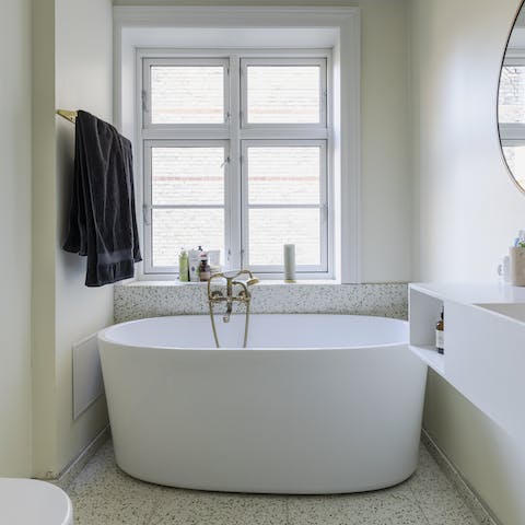 Sink back into soothingly warm waters in the ultra-chic freestanding bathtub