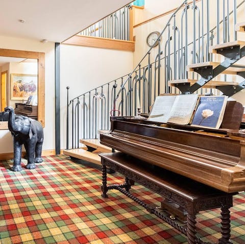 Enter the charming home and find a grand piano under the statement-making staircase 