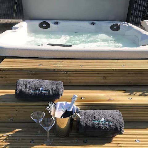 Treat yourself to a relaxing soak in the private hot tub, a glass of Prosecco in hand 