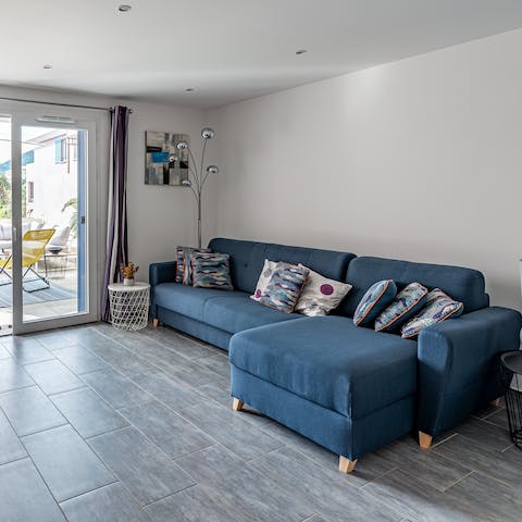 Kick back and snuggle up for a cosy evening of movies on the large sofa