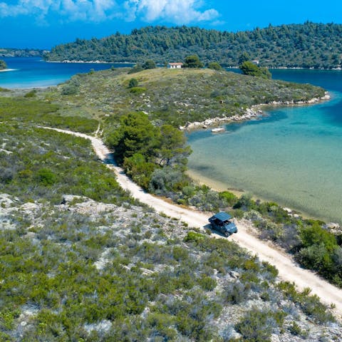 Explore the pine-covered Diaporos Island, surrounded by warm and shallow waters