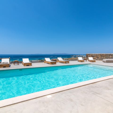 Swim laps in the turquoise pool as the Aegean shimmers in the background