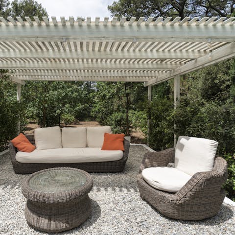 Pop open a bottle of fizz and unwind on the comfortable rattan sofa