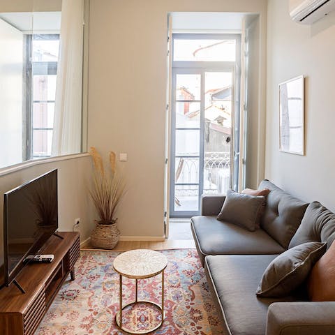 Relax in the bright living room with a glass of Portuguese wine after a busy day of exploring