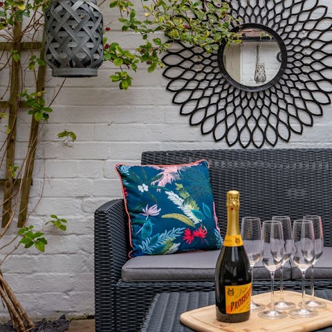 Enjoy a glass of fizz in the pretty, walled garden on arrival