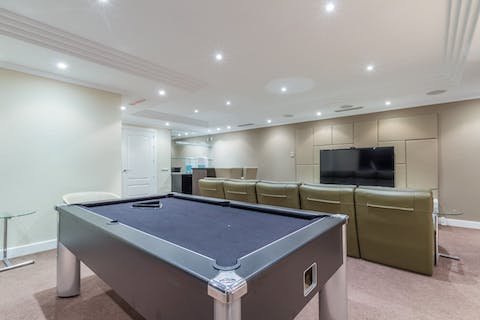 Play a pool tournament in this home cinema room, which leads you into a private gym