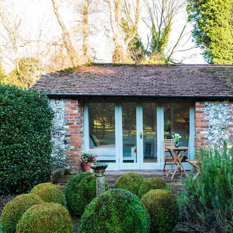Stay in a hand-built, flint-stone cottage at the edge of a pretty garden