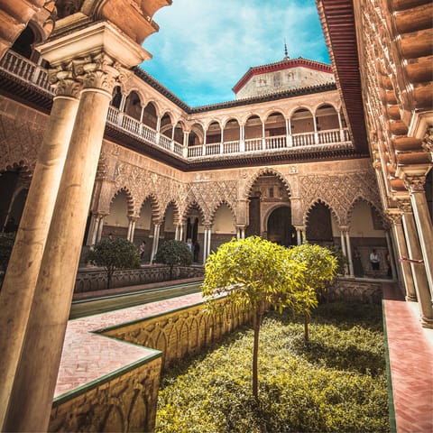 Visit the grand Royal Alcázar of Seville, a short walk from your apartment