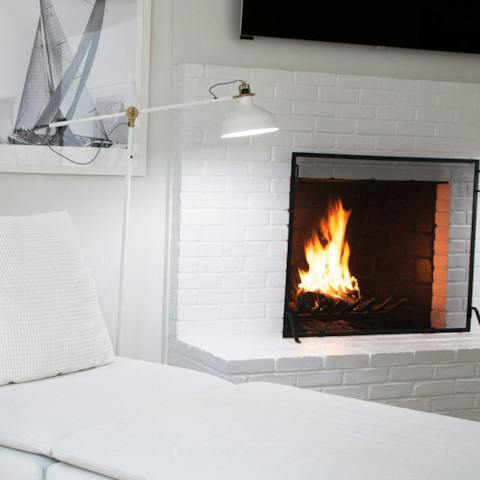 Get cosy with a good book on the white chaise lounge, in front of the fireplace 