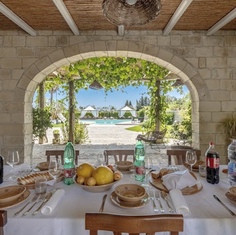 Sit down to an Apulian feast and admire how the stone arch frames the leafy pergola ahead