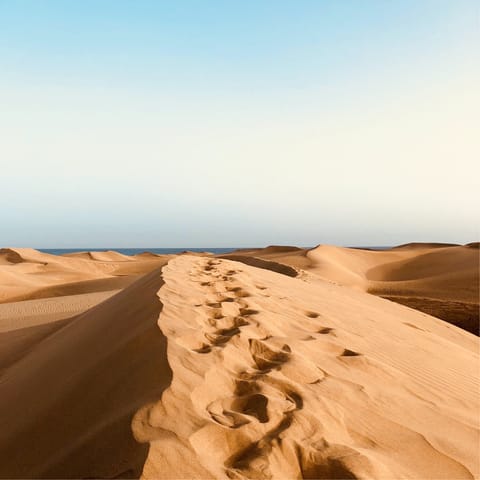 Sink your toes into the sand at Playa de Maspalomas, a sixteen-minute drive away