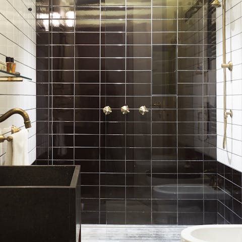Take a long soak in the black and white tiled bathroom with elegant brass fittings