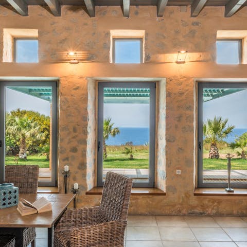 Gaze out to views of the azure seas from huge windows throughout the villa