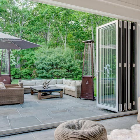 Open the bi-fold doors to the seating area with its patio heater