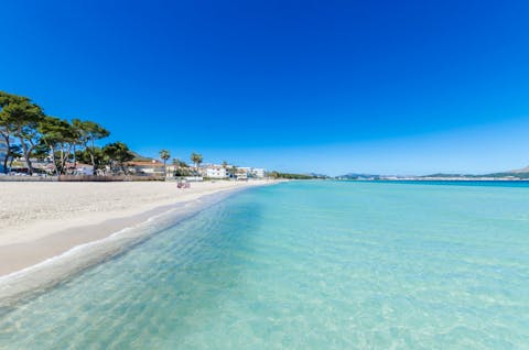 Soak up the crystal clear waters of Playa de Muro, mere footsteps away