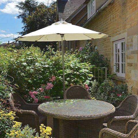Enjoy a glass of wine on the patio amidst the flora of the garden