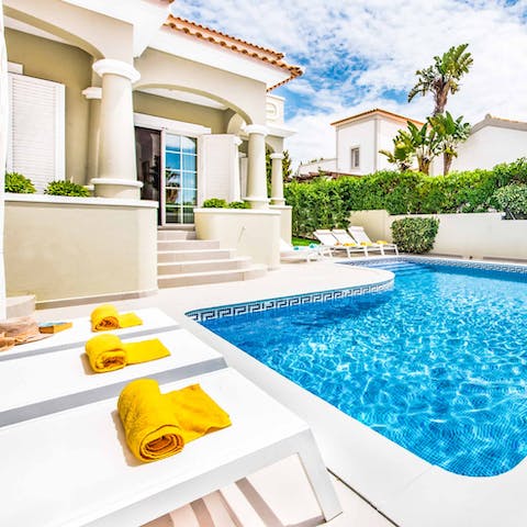 Relax poolside on the villa's dazzling sun deck