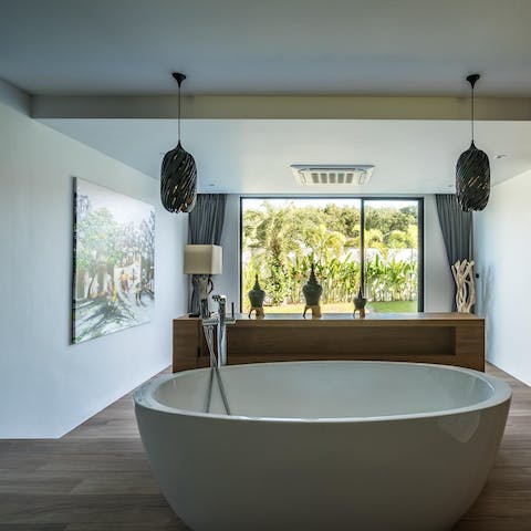 Rejuvenate in your free-standing bath, accompanied by palm tree views