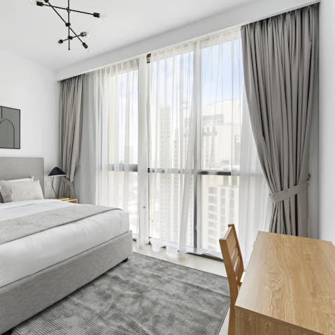 Work at the desk in the main bedroom where sunlight streams in through floor-to-ceiling windows