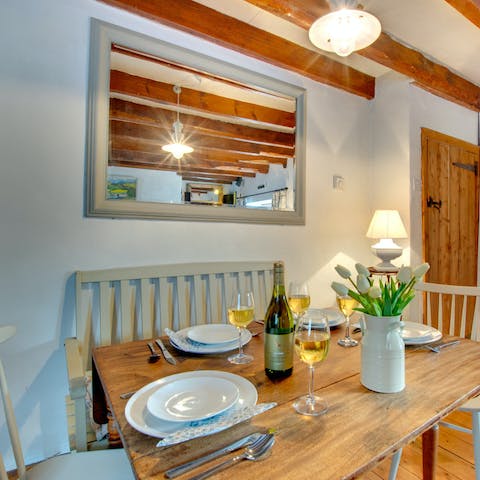 Enjoy a homecooked meal and bottle of wine around the dining table, beneath the wooden beams