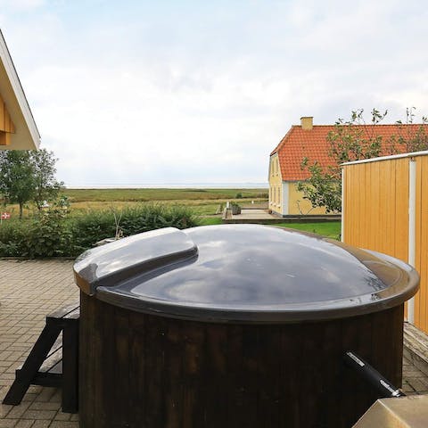 Soak in the hot tub with the serene view of lush, green pastures