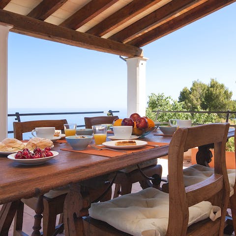 Dine on the covered terrace with views of the sea
