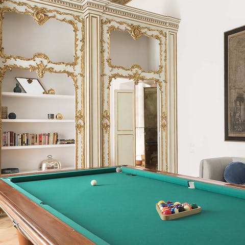 Play pool surrounded by gilded details and contemporary artwork