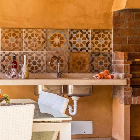 Cook up a rustic feast in the pretty mosaic summer kitchen
