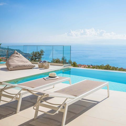 Enjoy views of the Ionian Sea while relaxing by the poolside