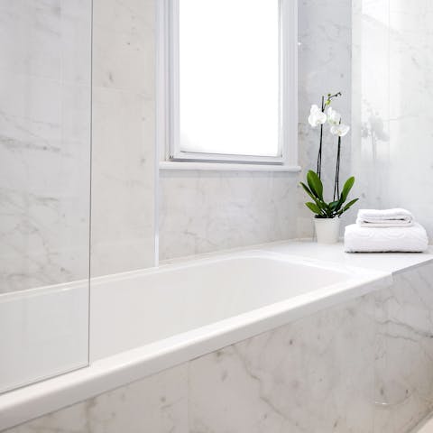 Sink into the deep marble bathtub