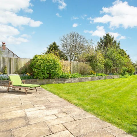 Relax on a lounger overlooking the lush, green garden