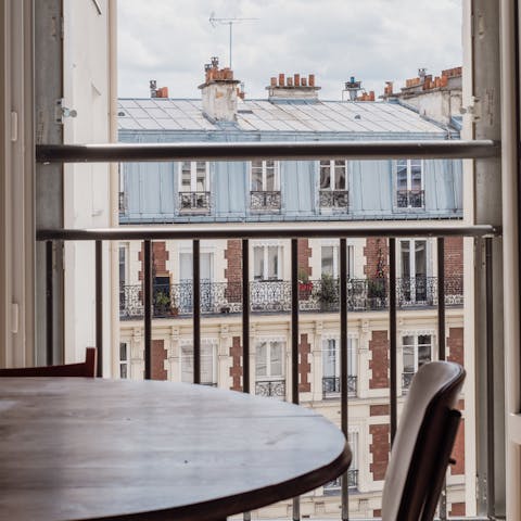 Tuck into a delicious dinner while admiring the Parisian rooftops