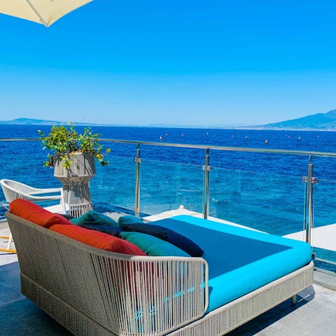 Admire the blue Tyrrhenian Sea from the plush sun bed