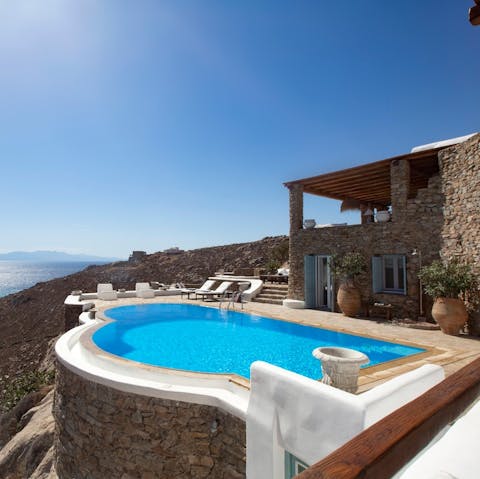 Gaze out at the Aegean’s tranquil waters as you lounge by the infinity pool