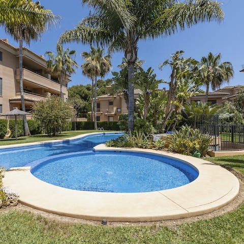 Enjoy a refreshing dip in your communal pool, surrounded by tropical gardens