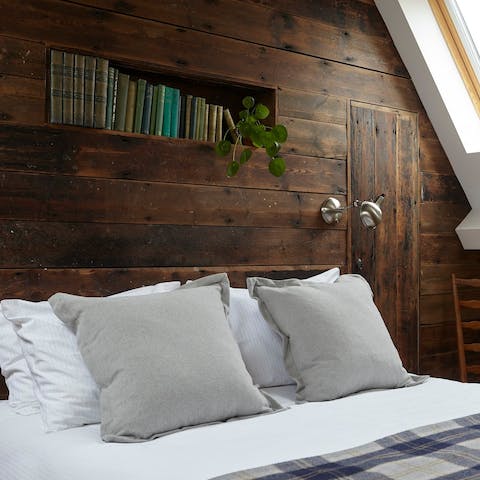 Cosy up in the rustic bedroom upstairs – we can't get enough of the timber panelling 