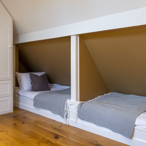 Sleep tucked into the second bedroom's clever bed spaces in the eaves