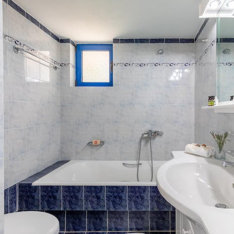 Finish the day with a soothing soak in the blue-tiled bathtub