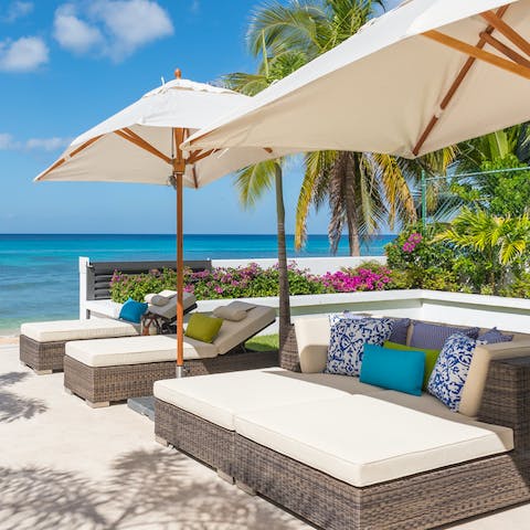 Pour yourself a cool drink and relax in the shade of your villa's plush loungers