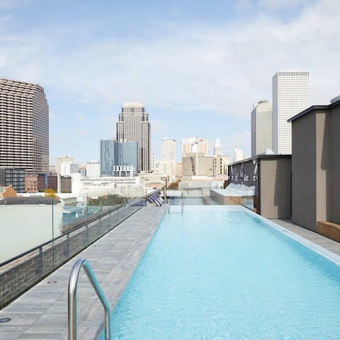 Swim laps in the rooftop pool with a city skyline view