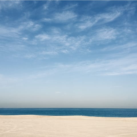Soak your toes into the sand of Jumeirah Public Beach, a fifteen-minute drive away