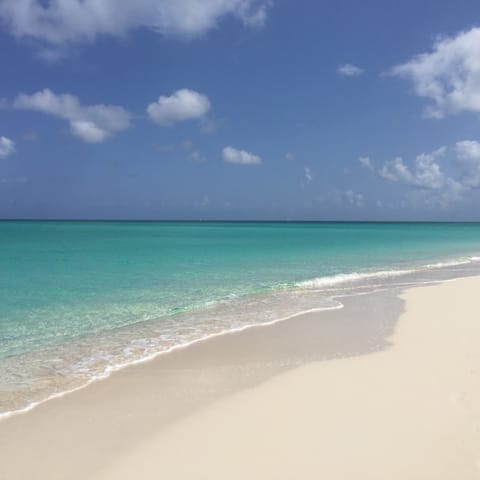 Sink your feet into the white sands of Grace Bay beach, a short drive away